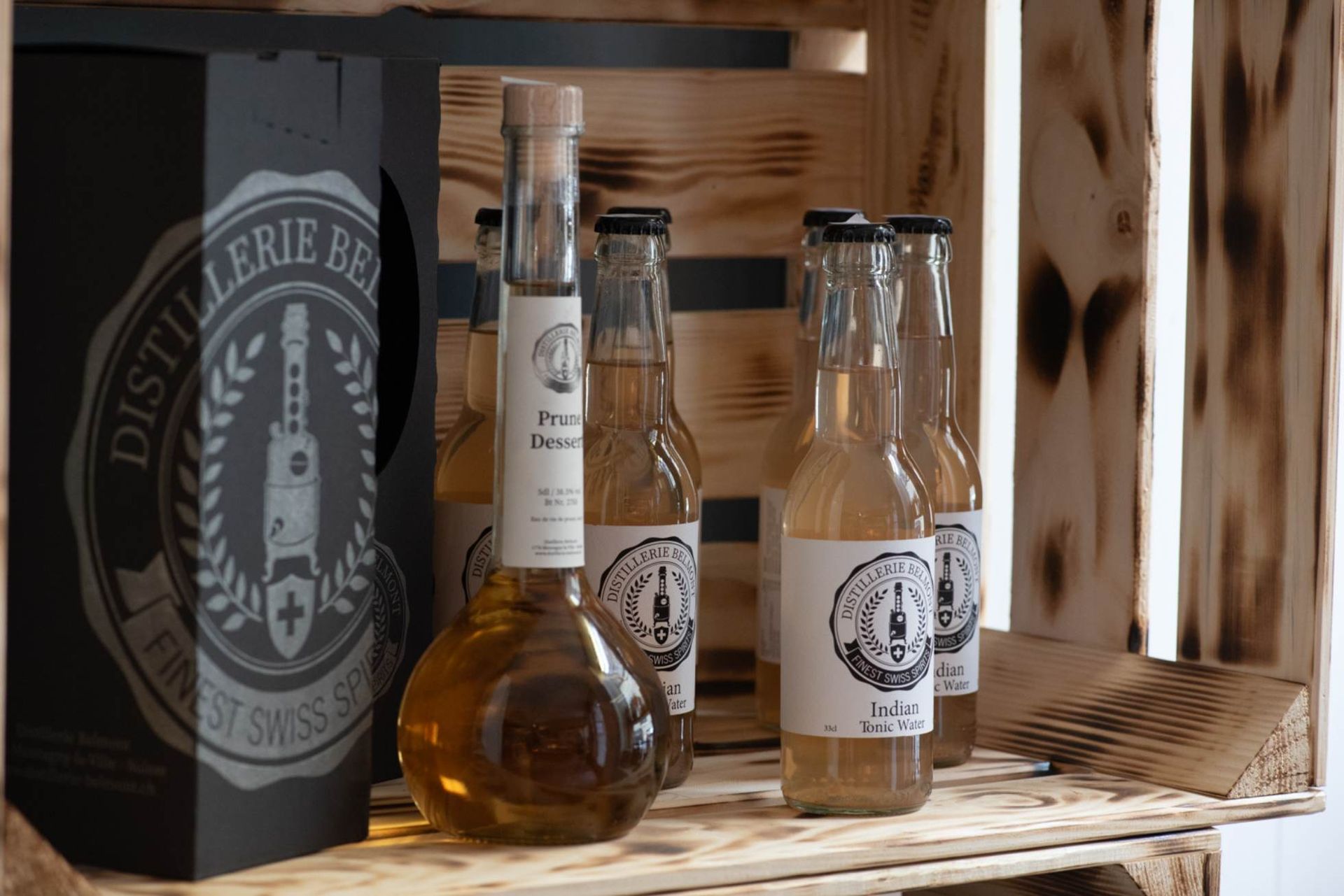 Bouteilles d'eau-de-vie de poire et de tonic, dans une caisse en bois avec une boîte de marque, Distillerie Reist.