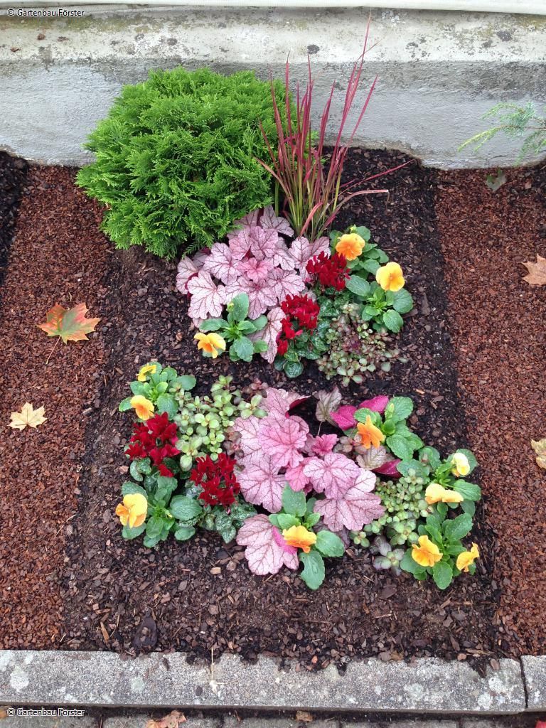 Grabgestaltung mit rosa, pinkfarbenen und gelben Blumen