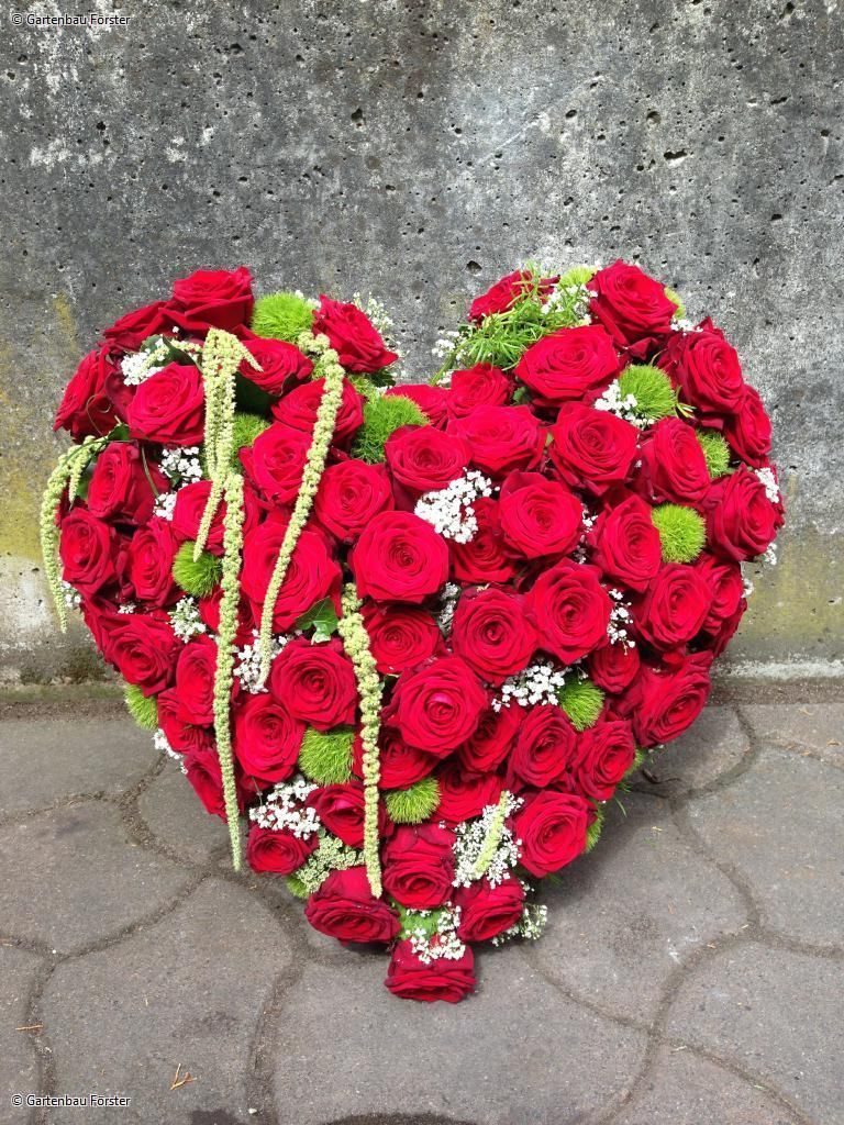 Herzförmiges Grabgesteck aus roten Blumen