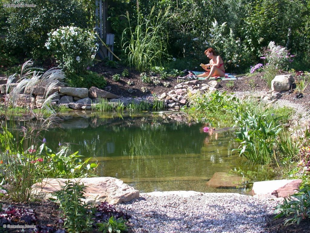 Frau sitzt in der Sonne an einem Teich