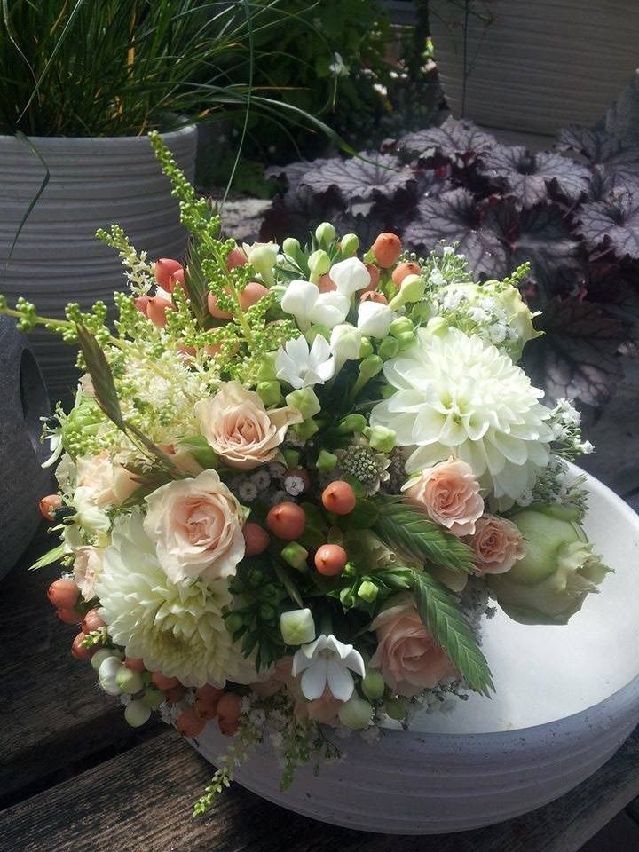 Brautstrauß mit weißen Rosen, Beeren und grünen Akzenten in natürlicher Floristik.