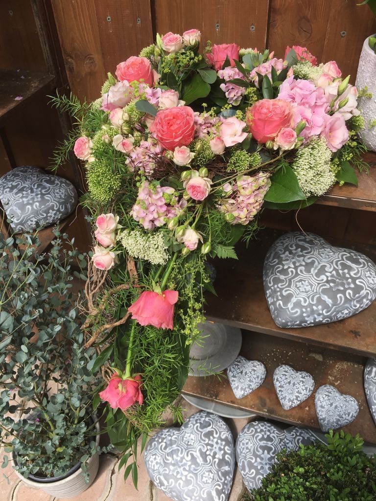 Blumengesteck in Rosa und Pink mit Pfingstrosen, Rosen und zarten Grünanteilen.