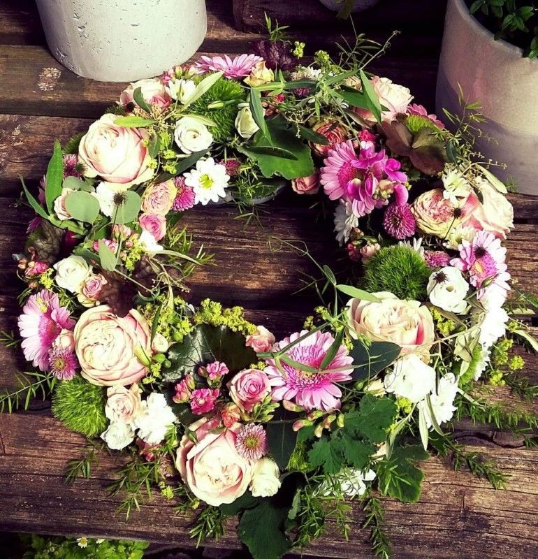 Vielfarbiger Trauerkranz mit rosa Rosen, Gerbera und grünem Efeu.