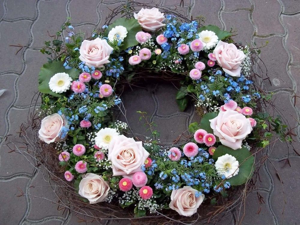 Runder Trauerkranz in Pastellfarben mit Rosen, kleinen Blüten und feinem Blattwerk.