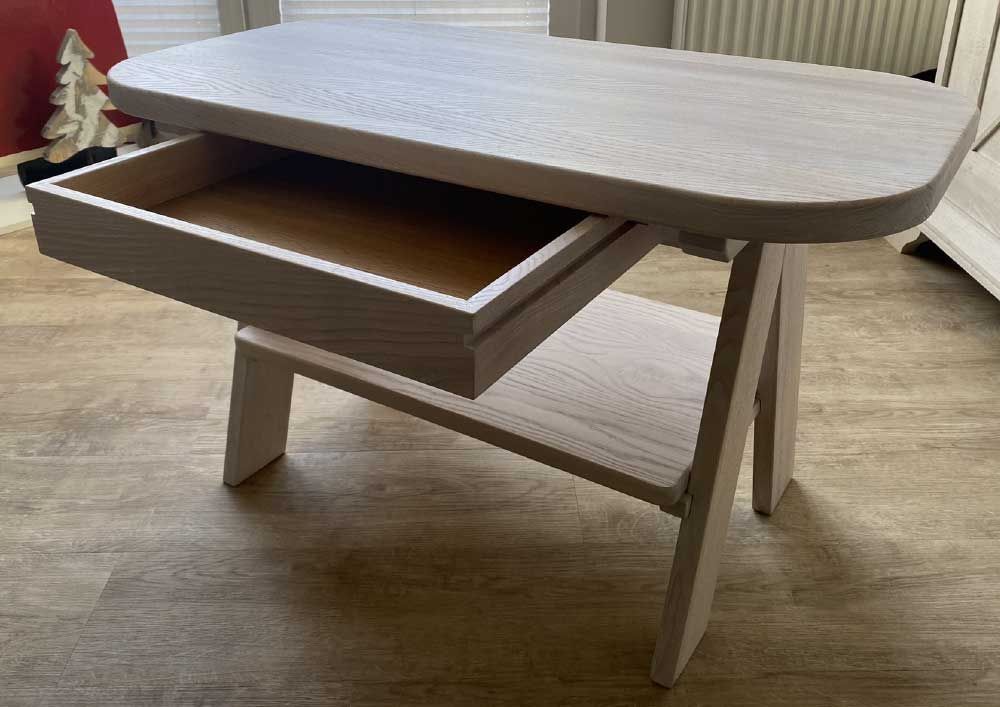 Heller Beistelltisch aus Holz mit offener Schublade und unterem Regal, für den Innenbereich.