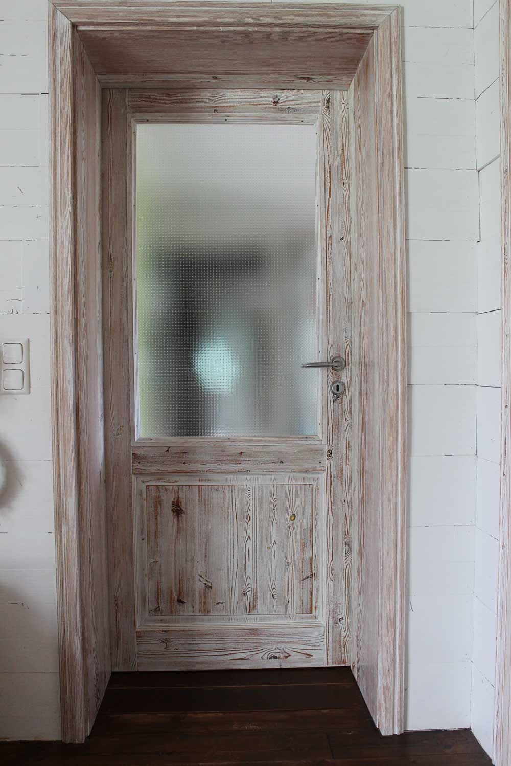 Holztür mit Milchglasplatte, helle Holzfarbe.