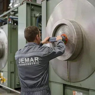 Un hombre está trabajando en una máquina en una fábrica.
