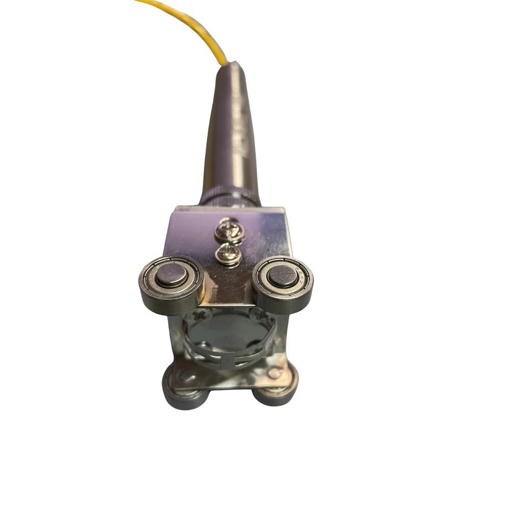 Dispositivo metálico con rodamientos de bolas, cable amarillo.