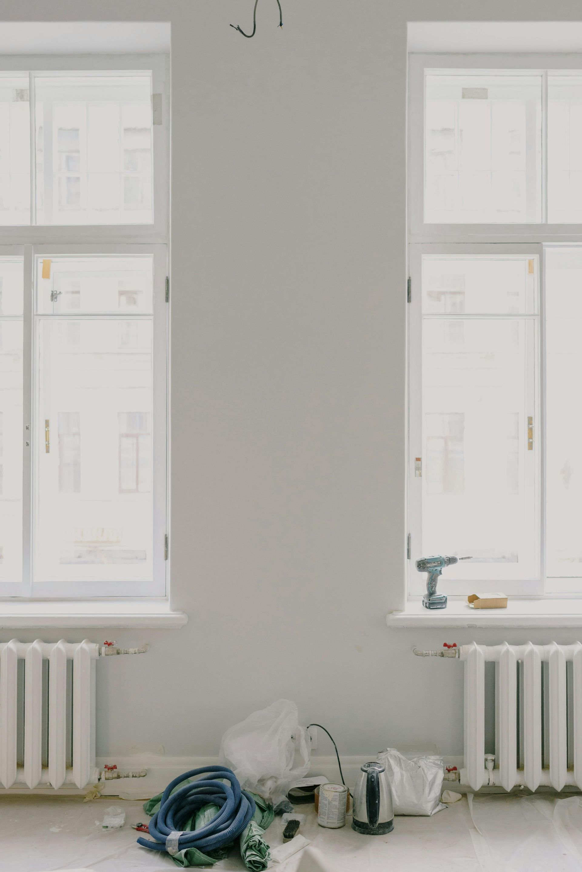 Una habitación con dos ventanas y radiadores en construcción.