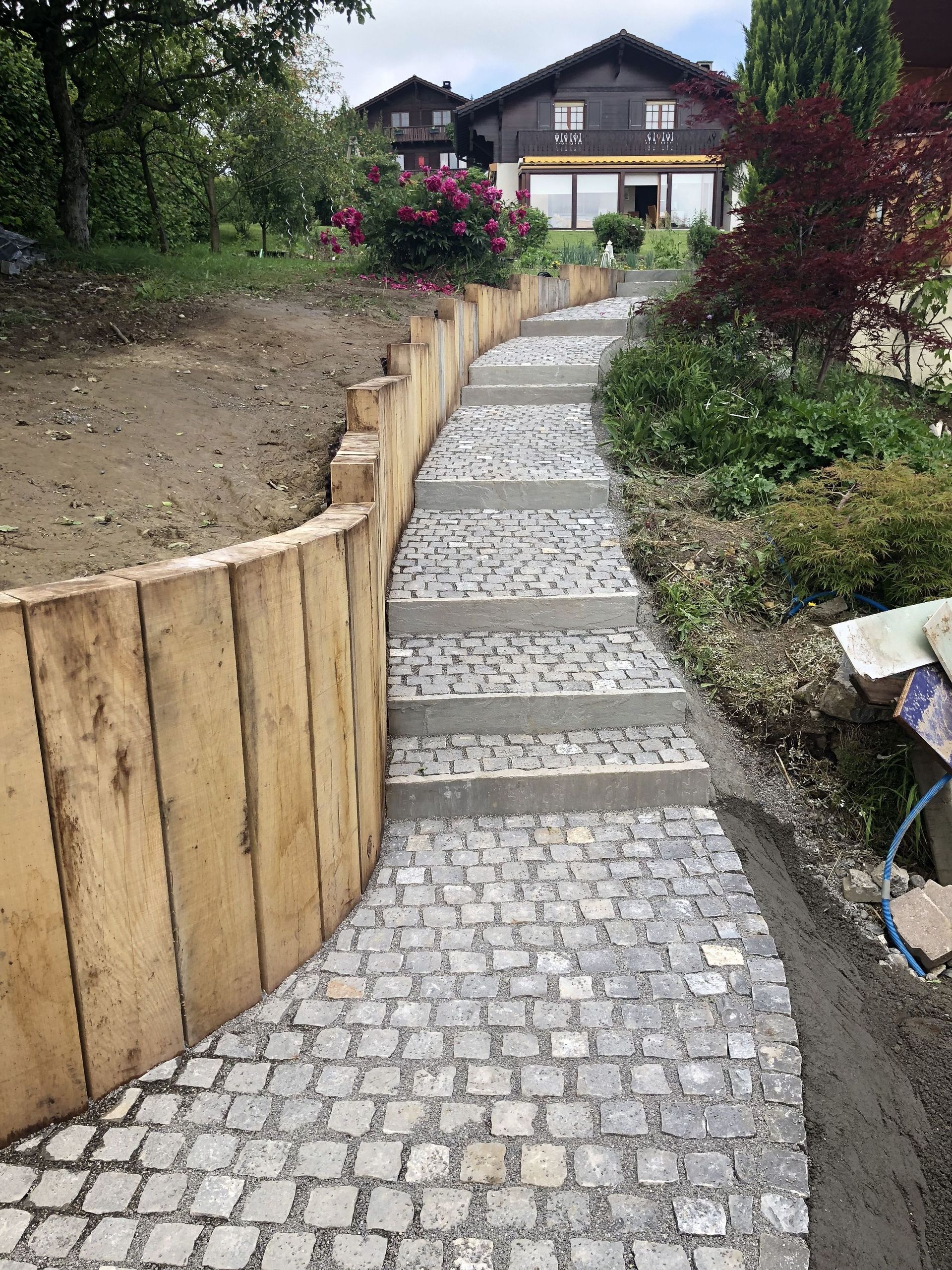 Pose verticale de traverses en chêne et pose de pavés en grès