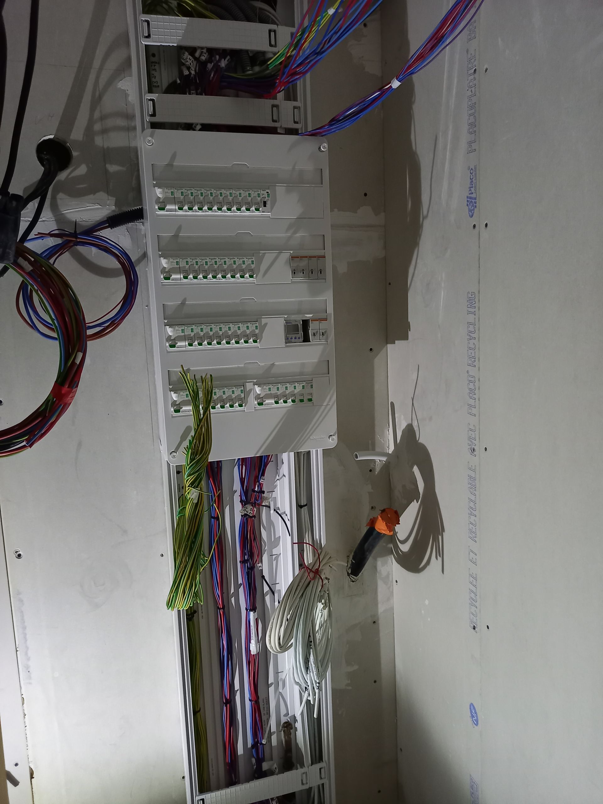 Pièce en travaux avec câblage électrique apparent et une fenêtre.