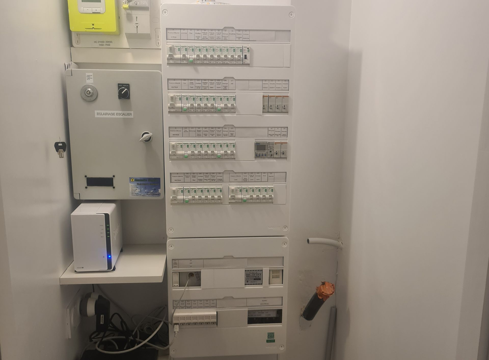 Tableau électrique avec disjoncteurs en position marche/arrêt et fils connectés.