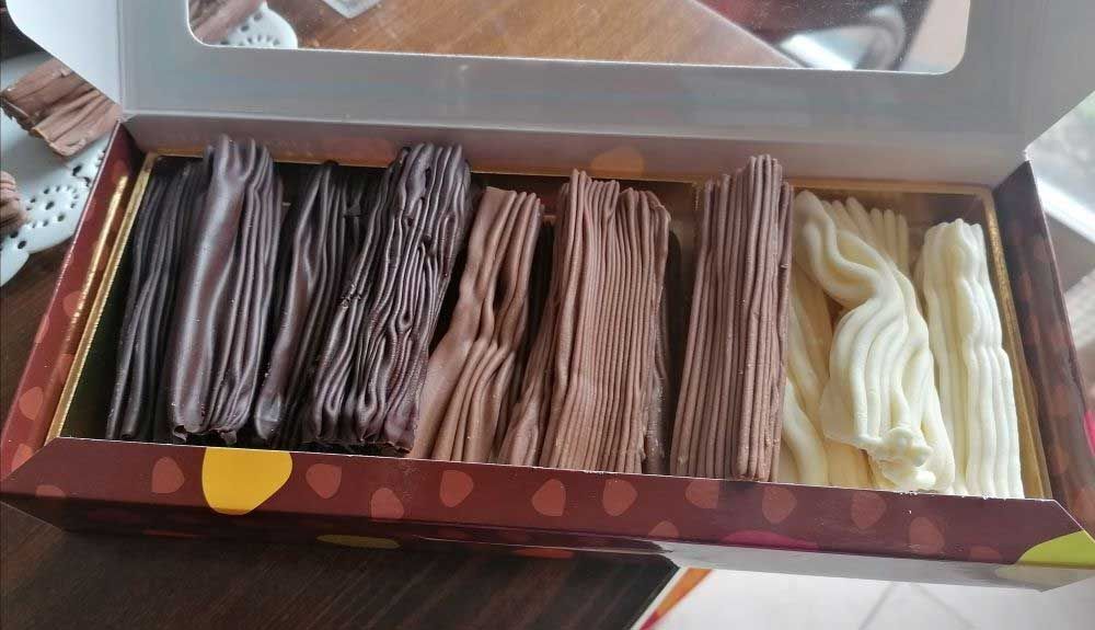 Una caja llena de diferentes tipos de palitos de chocolate