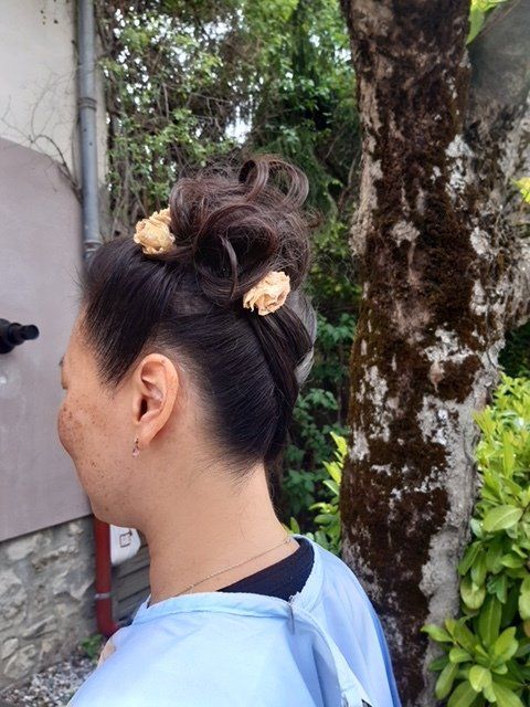 Coiffure de mariée avec fleur beige de profil