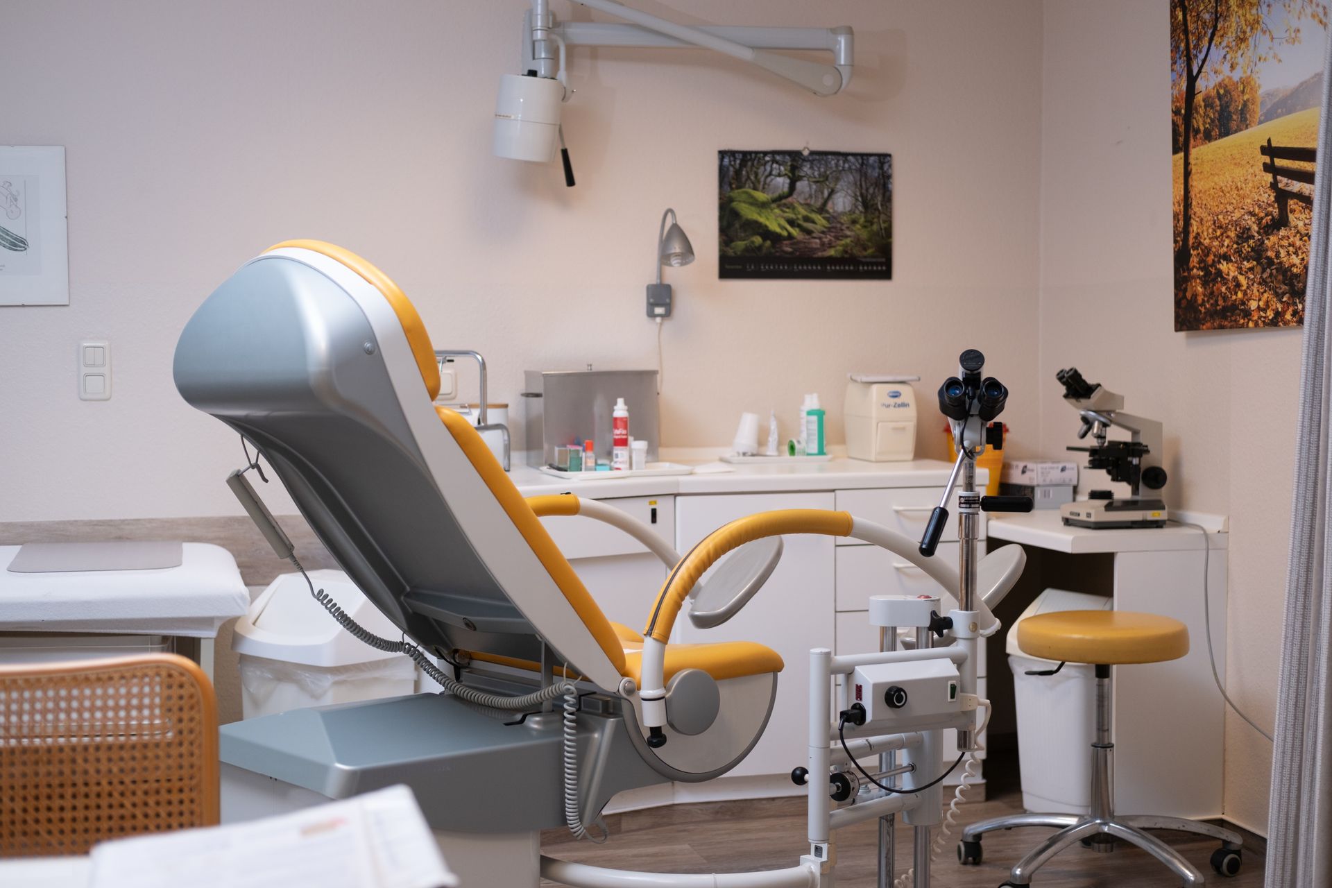 Eine Arztpraxis mit einem gynäkologischen Stuhl und einem Mikroskop.