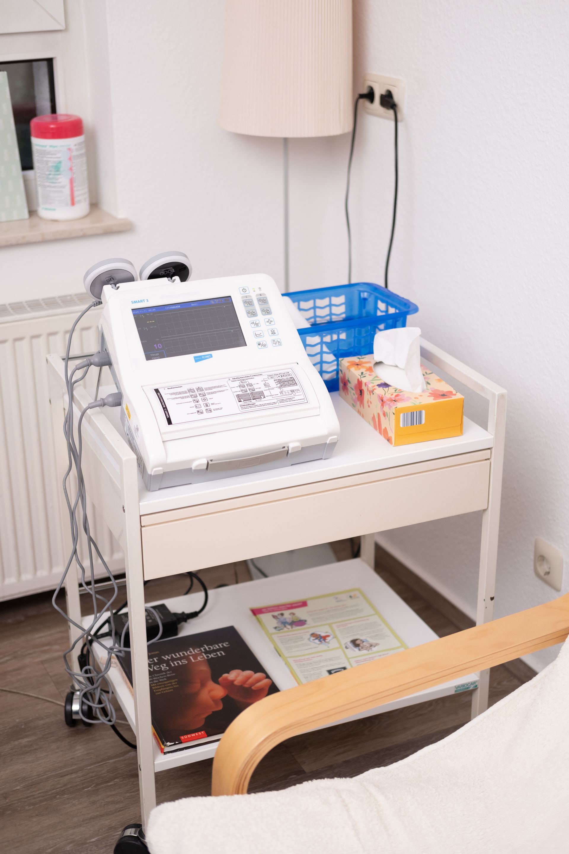 Auf einem Tisch neben einem Stuhl steht ein medizinisches Gerät.