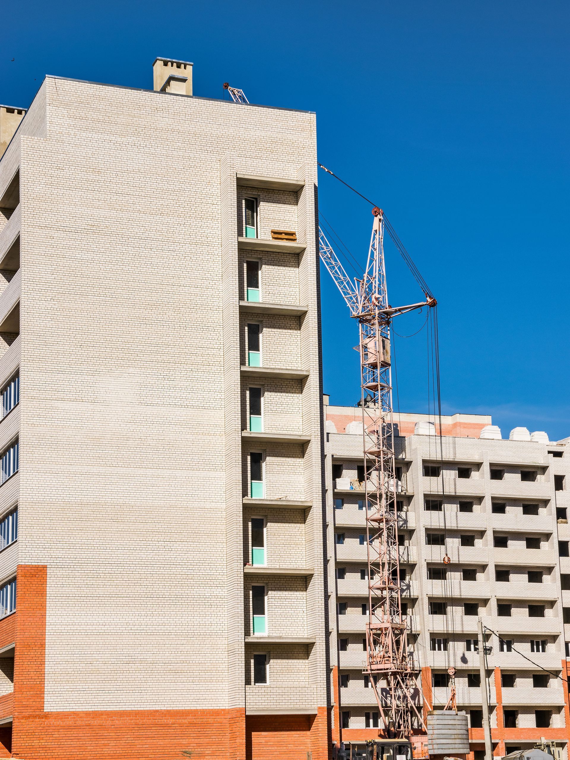 De hauts immeubles d'appartements en construction se détachent avec des grues et des échafaudages.