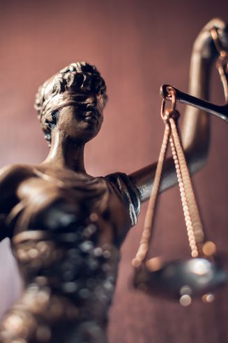 Statue en bronze de la Dame Justice tenant une balance.