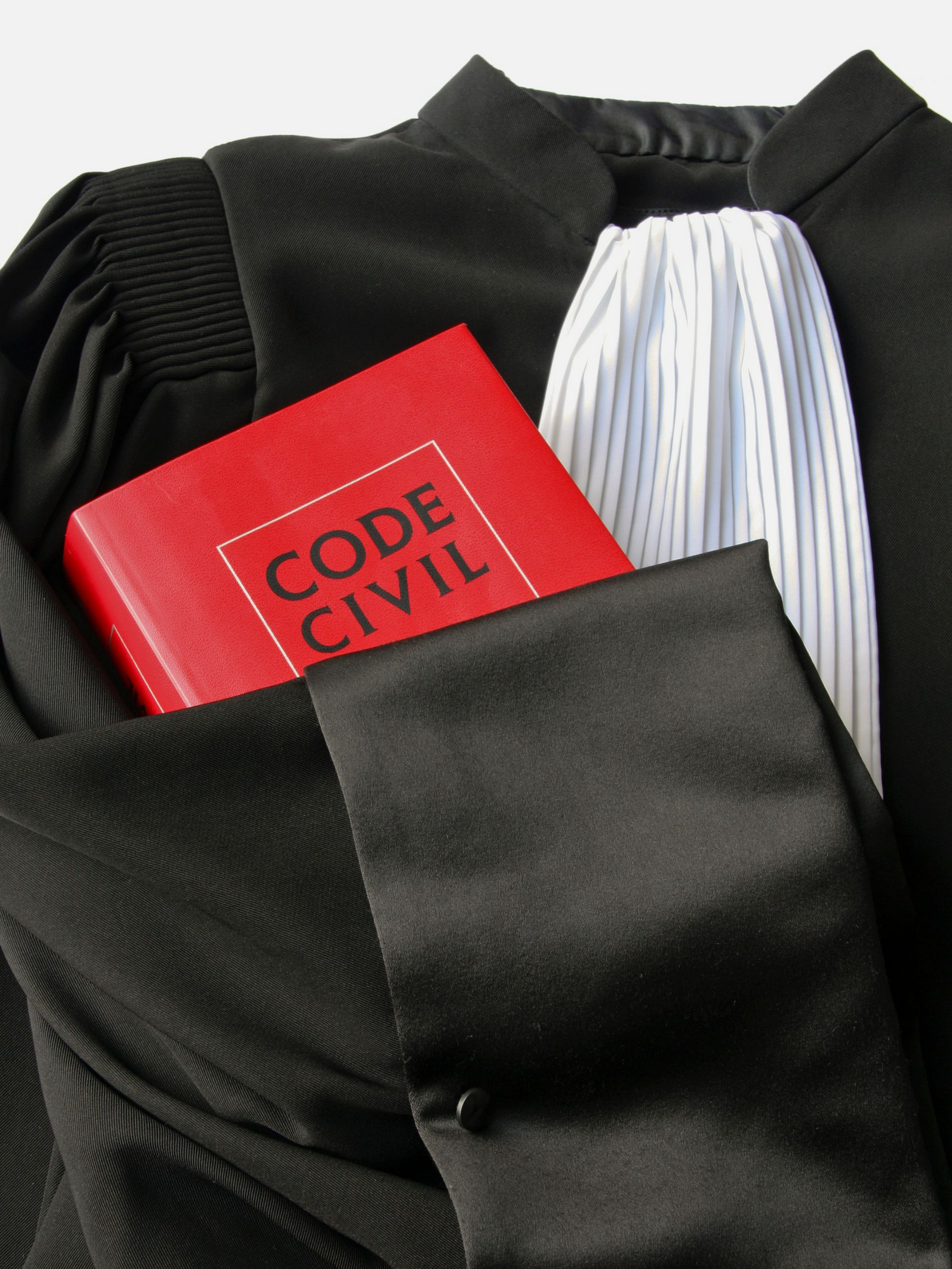 Robe d'avocat et livret rouge du Code civil.
