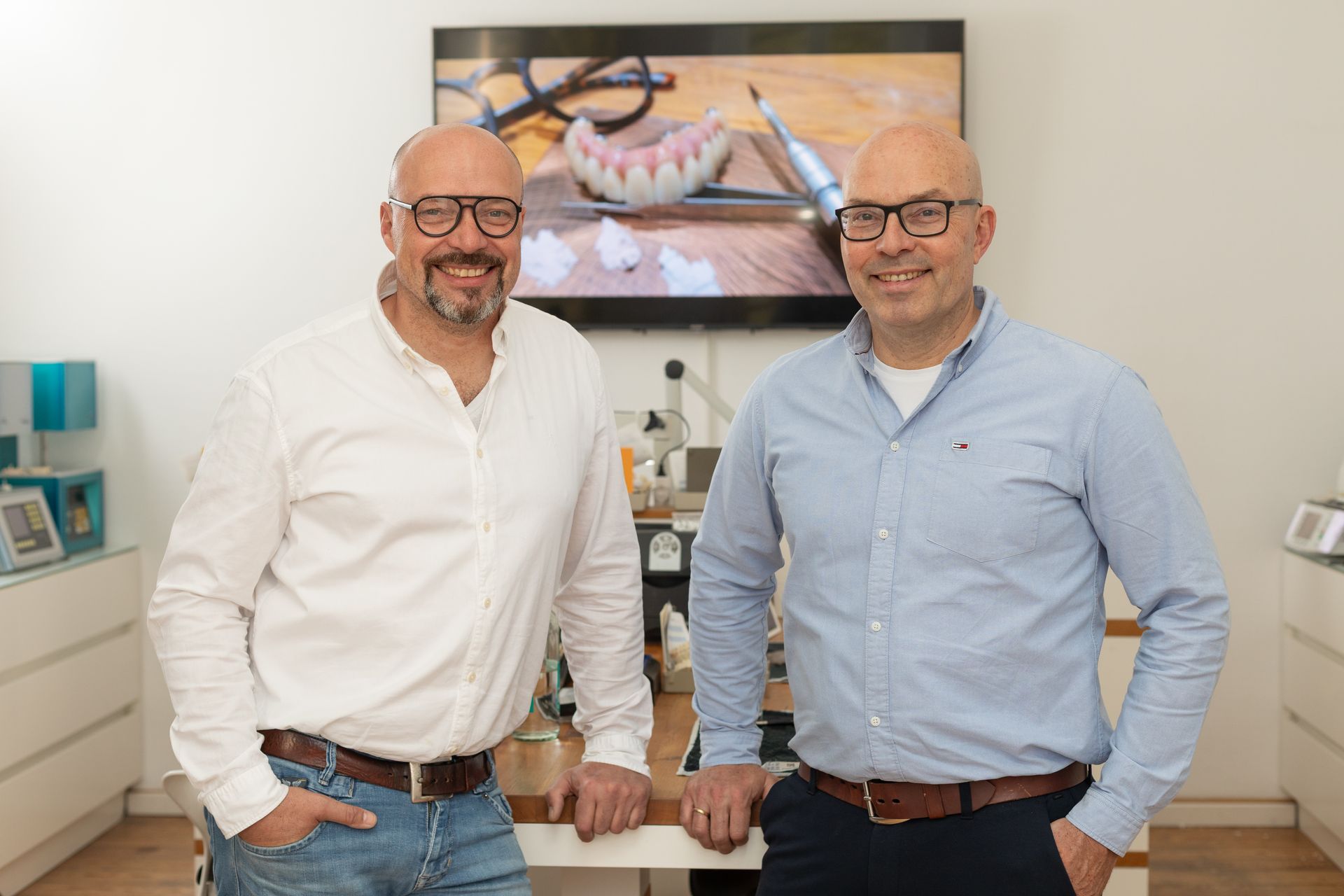 Zwei Männer stehen in einem Flur neben einer Treppe.