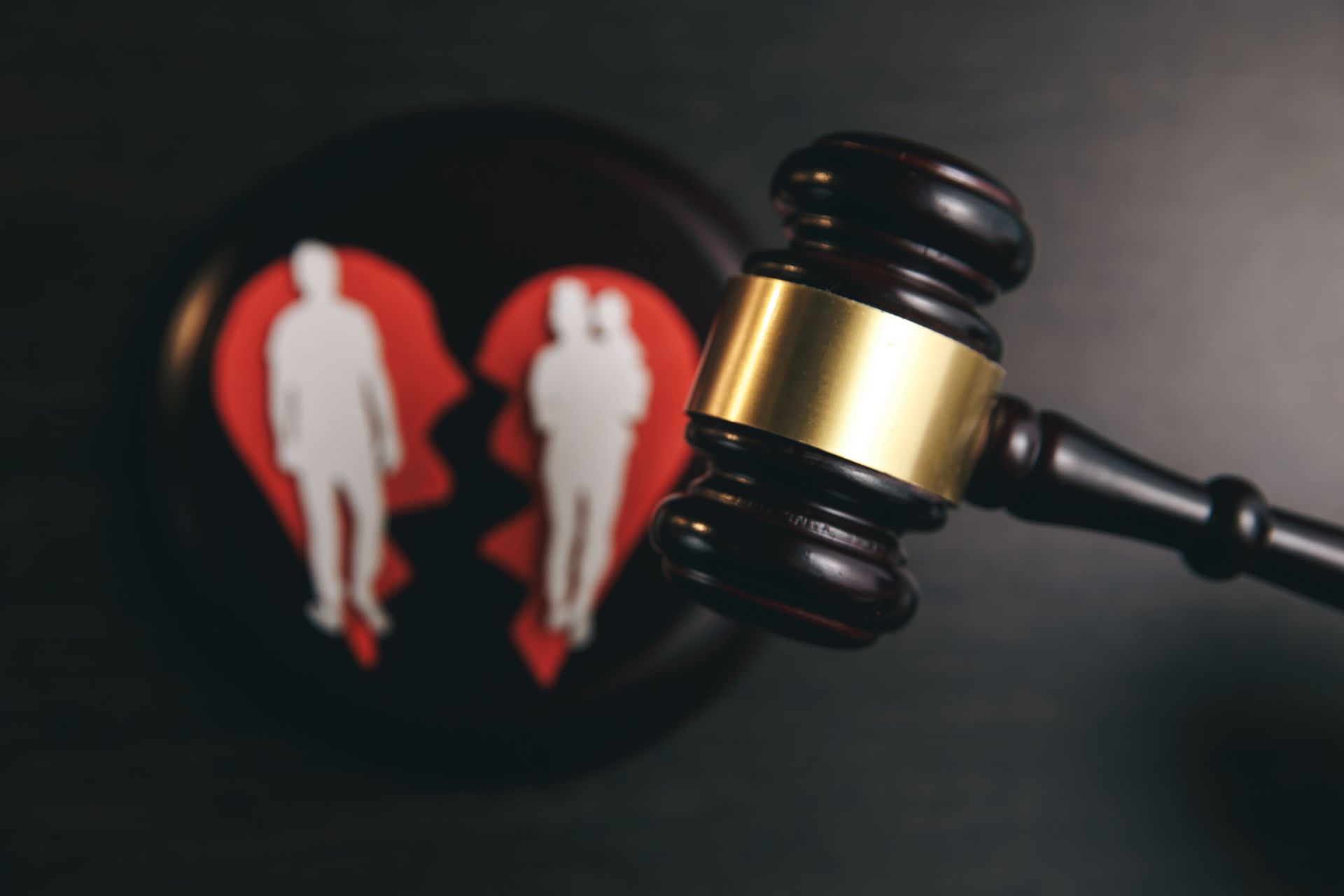 Un mazo reposa sobre un concepto de divorcio; corazón roto con siluetas de una pareja.