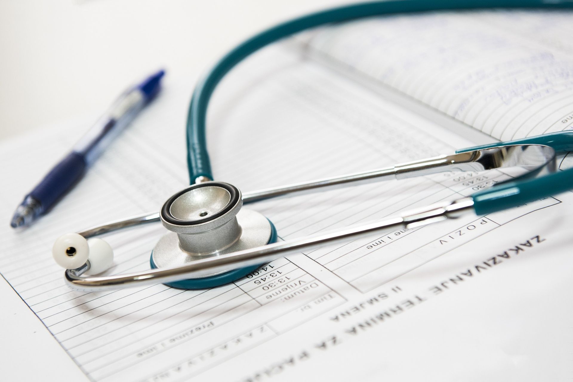 Estetoscopio sobre un formulario médico con un bolígrafo, probablemente en el consultorio de un médico.