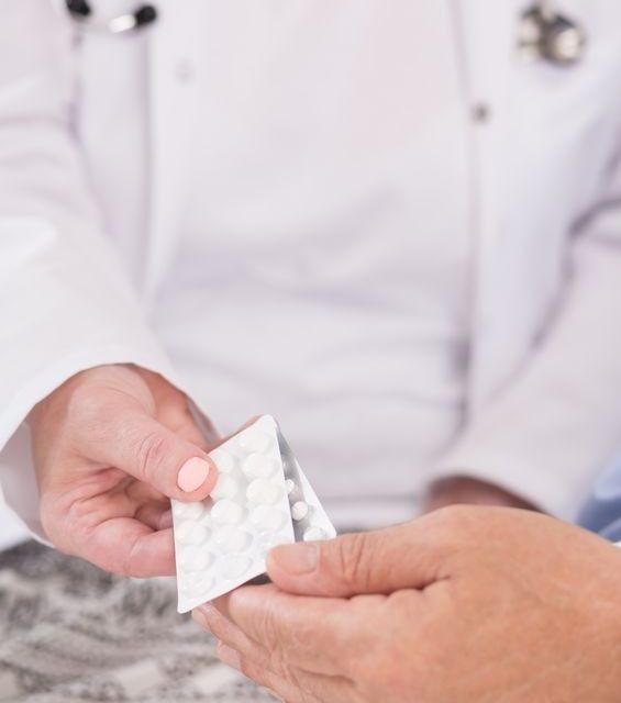 El médico entrega un blíster de medicamentos a un paciente.