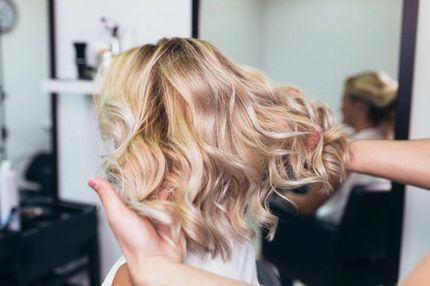 Frau mit blonden Haaren im Salon von Coiffure mina