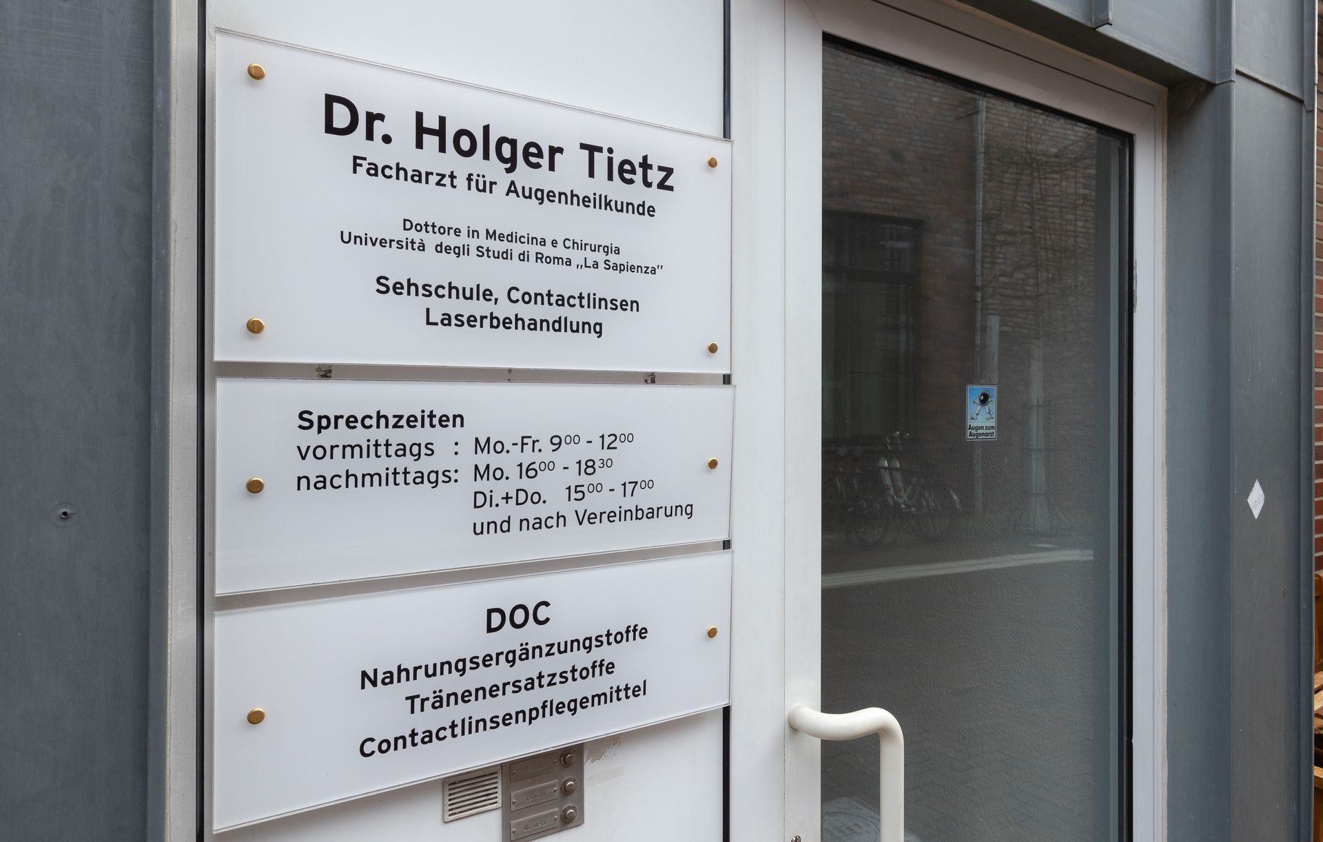 Eine Tür mit einem Schild darauf, auf dem steht: Dr. Holger Tietz