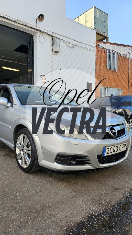 Opel Vectra plateado estacionado frente a una puerta de garaje abierta con la palabra