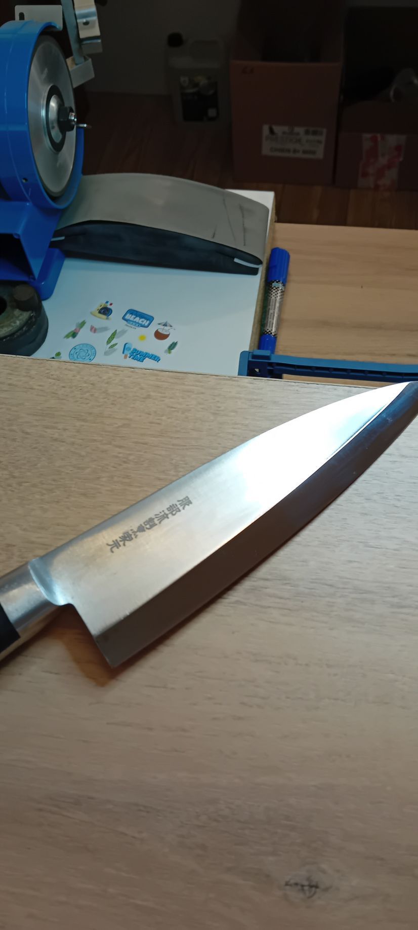 Un couteau japonais pour la cuisine posé sur une table en bois.