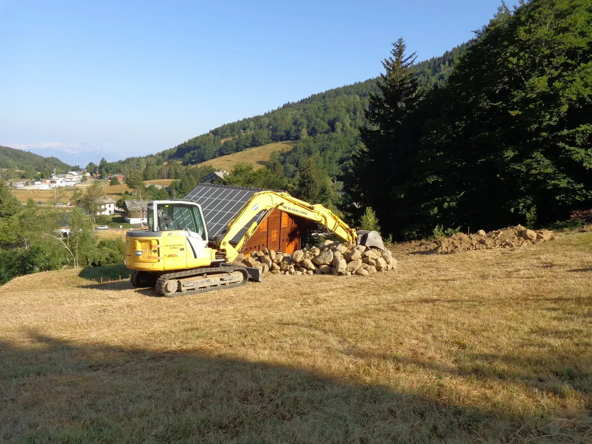 Travaux avec un entier de chantier devant un chalet en bois