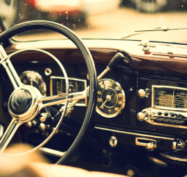 Un gros plan du volant et du tableau de bord d'une vieille voiture