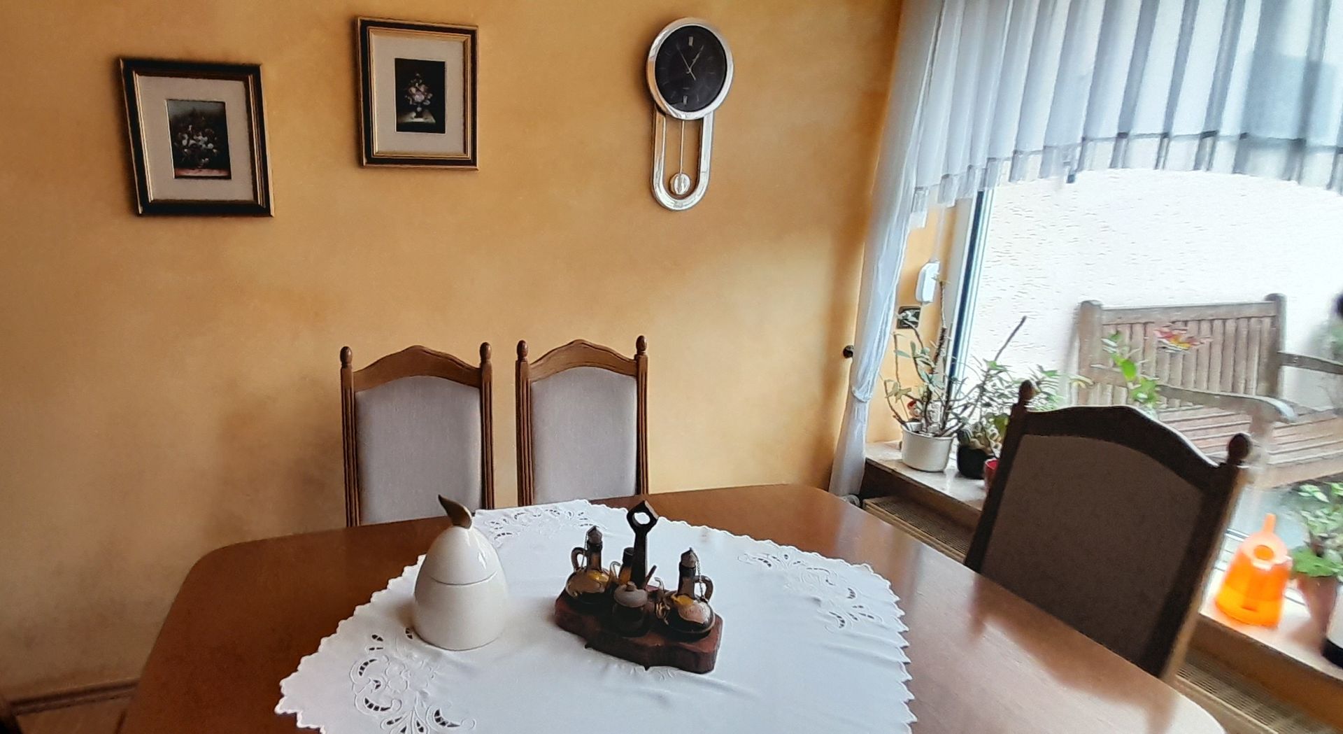 Ein Esszimmer mit Tisch und Stühlen und einer Uhr an der Wand, die in Terracotta gestrichen wurde
