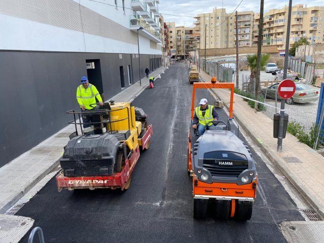 Resurfacing en curso. Obreros y maquinaria de construcción en la calle frente a un Burger King.