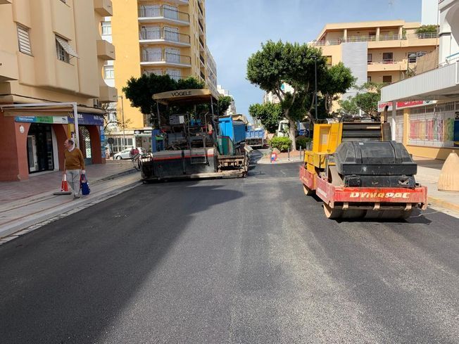 Resurfacing de road: Maquina pavimentadora de asfalto y rodillo en una calle de la ciudad, asfalto negro fresco.