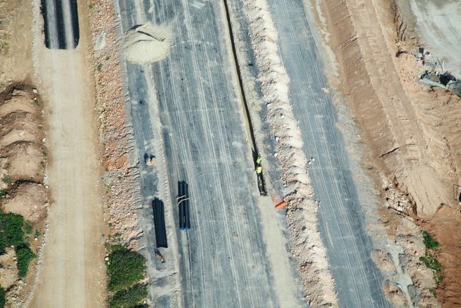 Vista aérea de un sitio de construcción: plataforma preparada con zanja y tuberías.