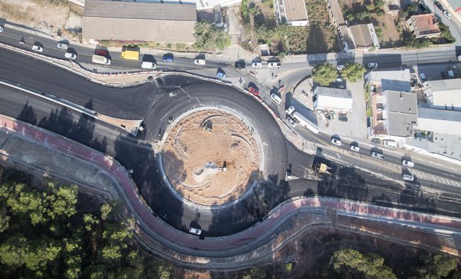 Vista aérea de una rotonda en construcción con vehículos circulando por las carreteras circundantes.
