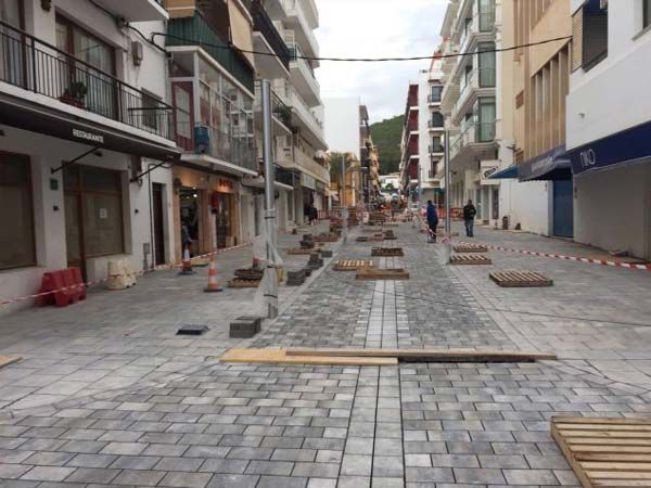 Fuentes con luces verdes que arrojan agua en una plaza de la ciudad por la noche.