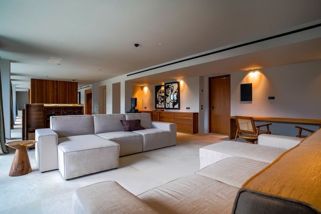 Sala de estar moderna con un gran sofá seccional y detalles de madera.