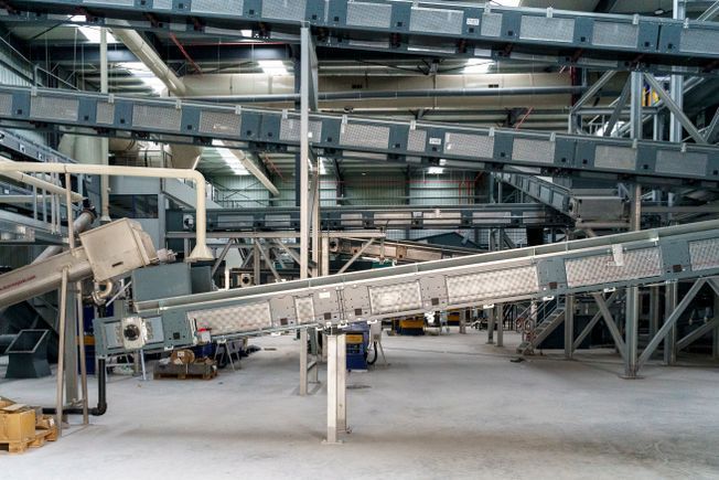 Cintas transportadoras en una gran instalación industrial, transportando mercancías.