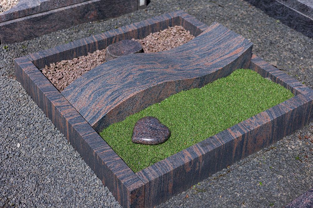 Ein Grab mit einem herzförmigen Stein in der Mitte.