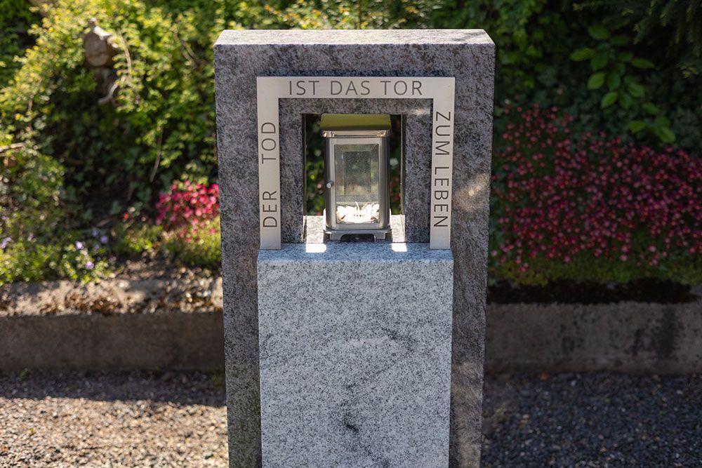 Ein Grabstein mit einer Laterne darin.