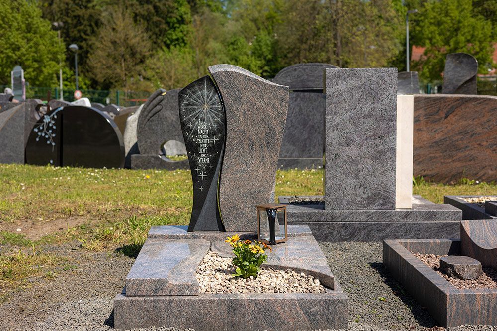 Ein Friedhof mit vielen Gräbern und einer Laterne in der Mitte.