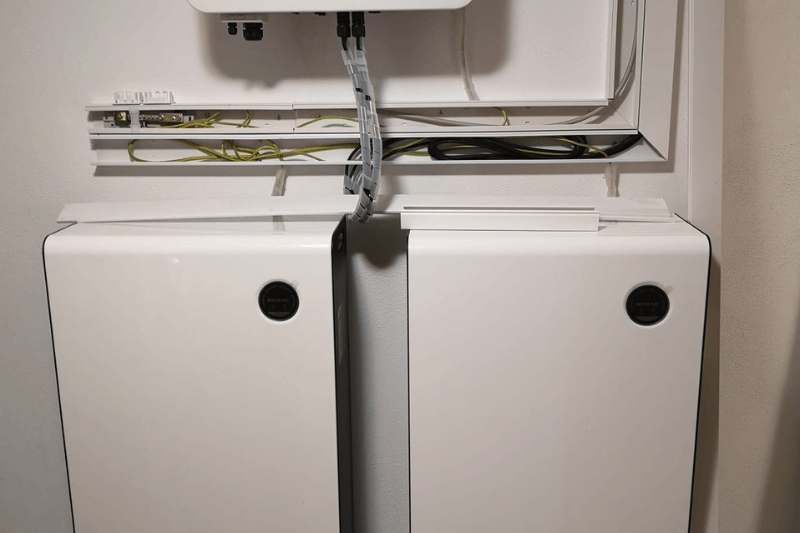 Zwei weiße Schränke stehen nebeneinander an einer Wand.