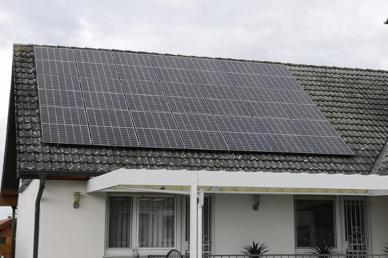 Ein Haus mit vielen Sonnenkollektoren auf dem Dach