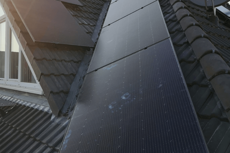 Eine Reihe von Solarmodulen auf dem Dach eines Hauses.