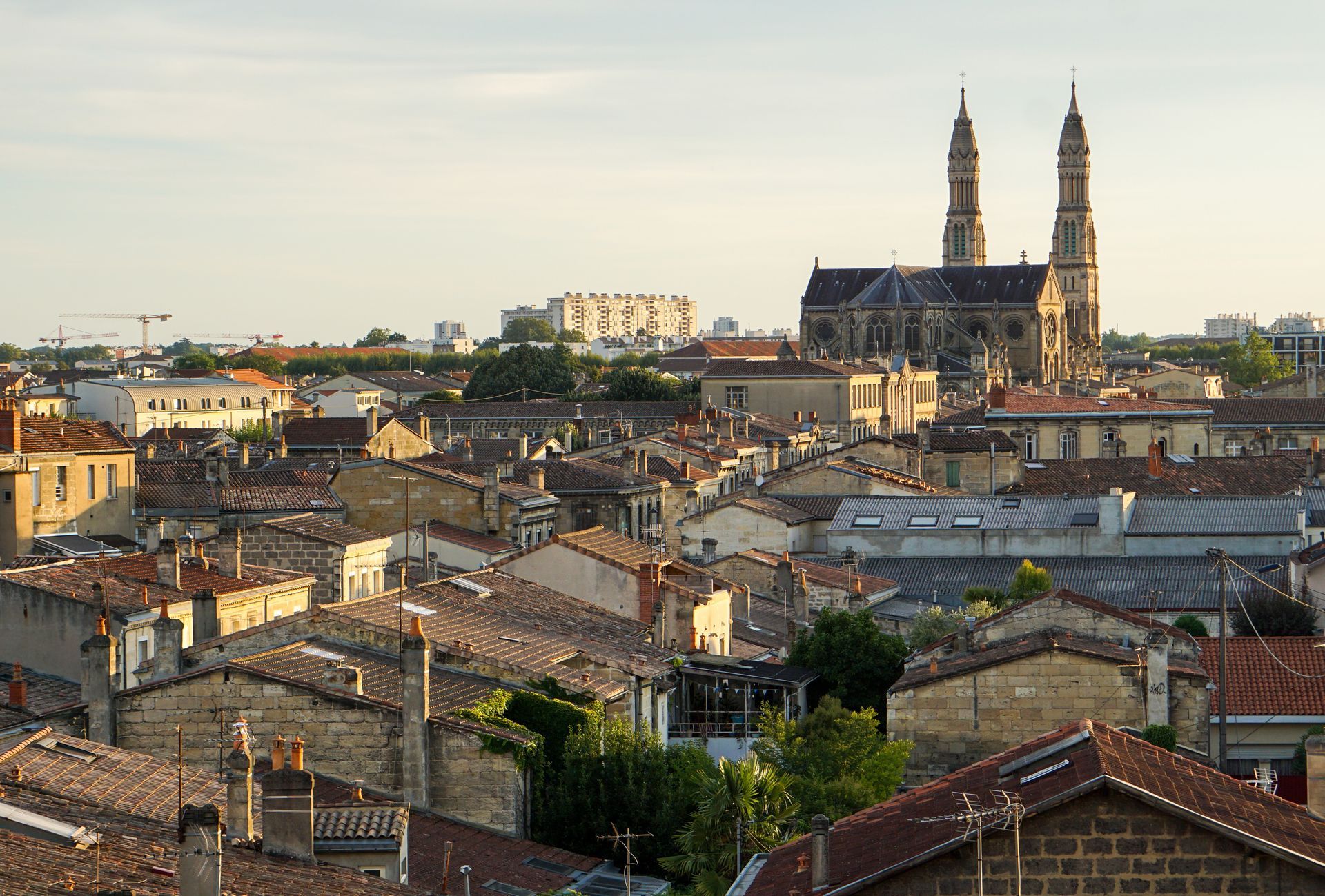 Vue ensoleillée de Bordeaux, en France, avec les deux hautes flèches de l'église Saint-Louis-des-Chartrons qui se dressent au-dessus des toits.