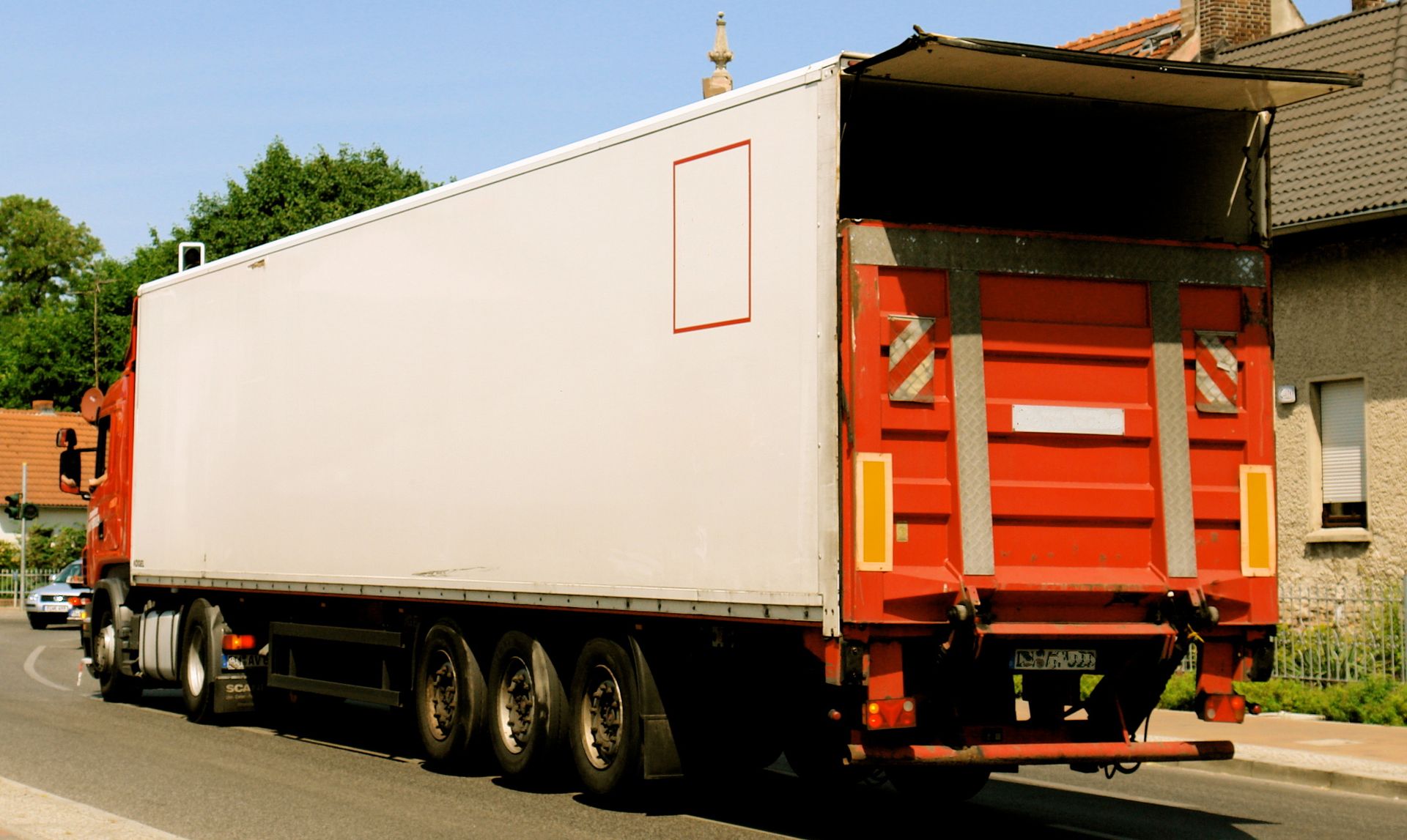 Un camion avec une grande remorque circule dans une rue.