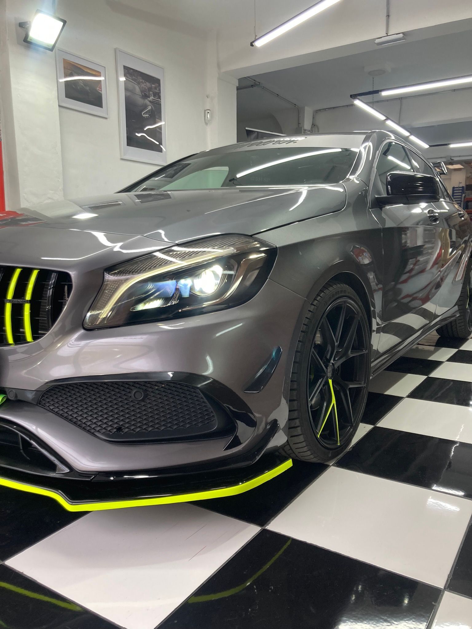 Un Mercedes Benz Clase A está estacionado en un garaje sobre un suelo cuadriculado.